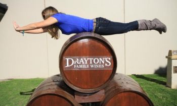 A woman lying on top of barrels at the 1 Day Hunter Valley Signature Wine Tour from Sydney with Colourful Collective Travel