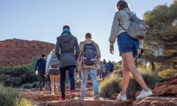 A  group of backpackers on a dirt path in the australian outback on a 5 day outback camping adventure