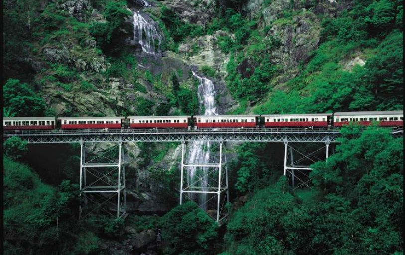 A train passing a waterfall in the rainforest