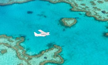 A plan flying over the iconic heart reef on the Great Barrier reef near the Whitsundays islands during a 60 minute scenic flight