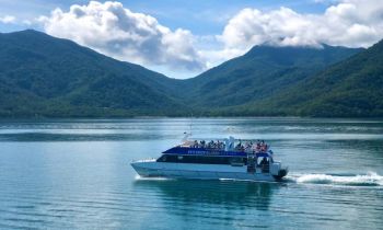 a boat on the way to fitzroy island with passengers seated on the roof