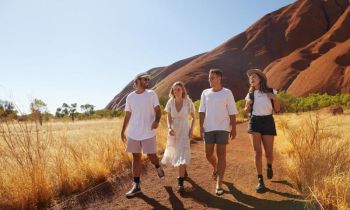 4 friends wearing white tshirts walking through the australian outback at Kings Canyon