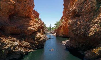 A view of someone swimming in a watering hole during the 4 day Uluru Kata Tjuta & Kings Canyon to West MacDonnell Tour