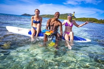 Three friends laughing and having fun in Fiji while Paddle boarding