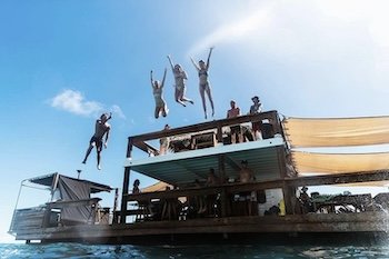 A group of backpakcers at the cloud 9 floating bar in Fiji having a great time