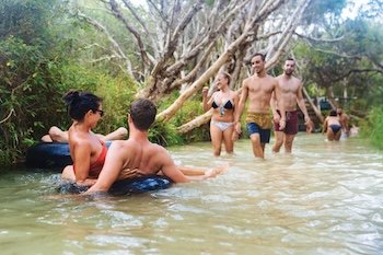 A group of backpackers floating down eli creek on kgari