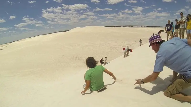Travellers explore golden sand dunes beneath a clear blue sky on the 8 Day Perth to Exmouth Return Tour, Western Australia.