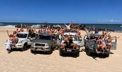 a group of friends having fun with on a 4wd on K'gari Fraser Island