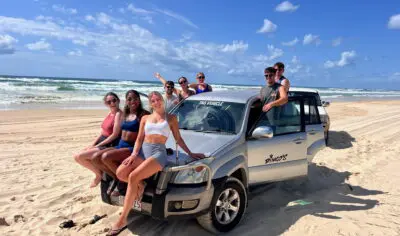 a group of friends having fun with on a 4wd on K'gari Fraser Island
