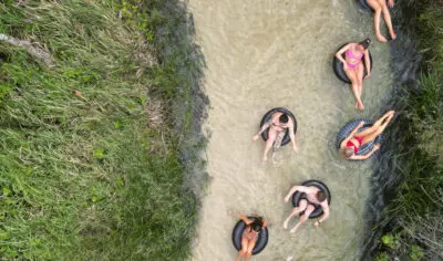 a group of friends having fun with inflatable tubes on a river