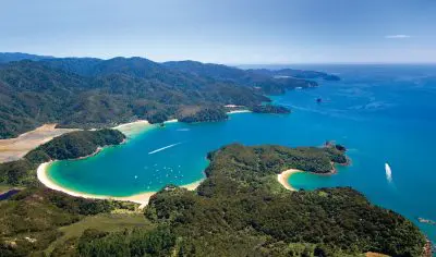 Stunning aerial view of the Three Day Classic’s lush green coastline, turquoise bays, and boats gliding under a vibrant blue sky.