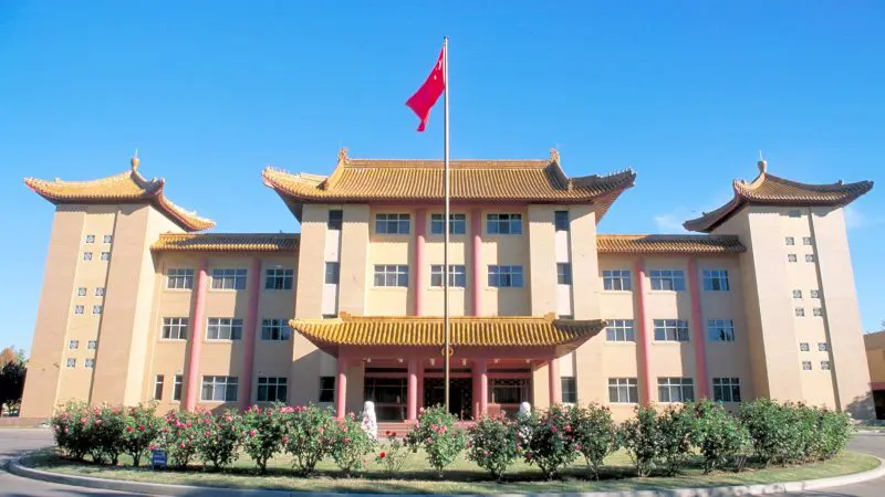 Impressive Chinese-style building with red flag under clear blue sky, ideal for a Canberra day trip from Sydney sightseeing tour.