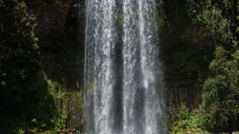 Girl enjoying Millaa Falls Waterfall in northern queensland