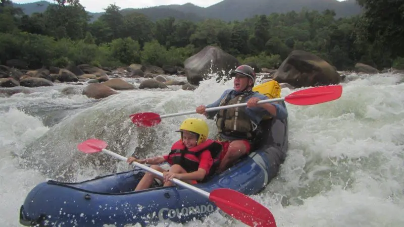 Adventurers in helmets and life jackets paddle through thrilling white-water rapids on an action-packed Half Day Sports Rafting tour.