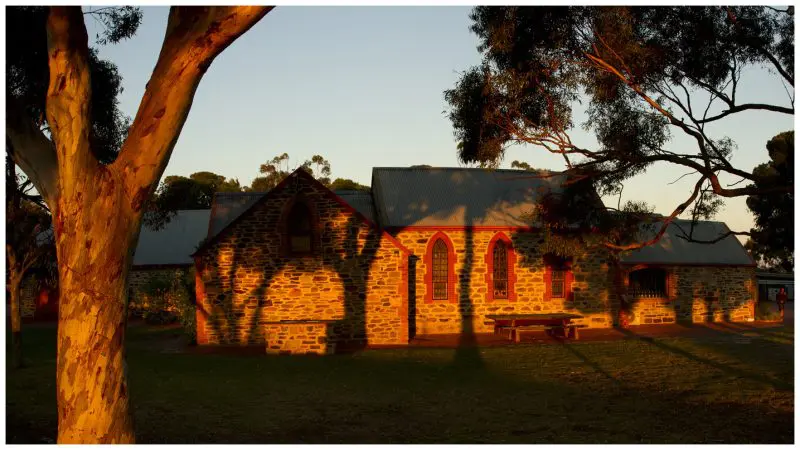 Historic stone building with arched windows glowing at sunset on the McLaren Vale North Hop On Hop Off Tour route, South Australia.