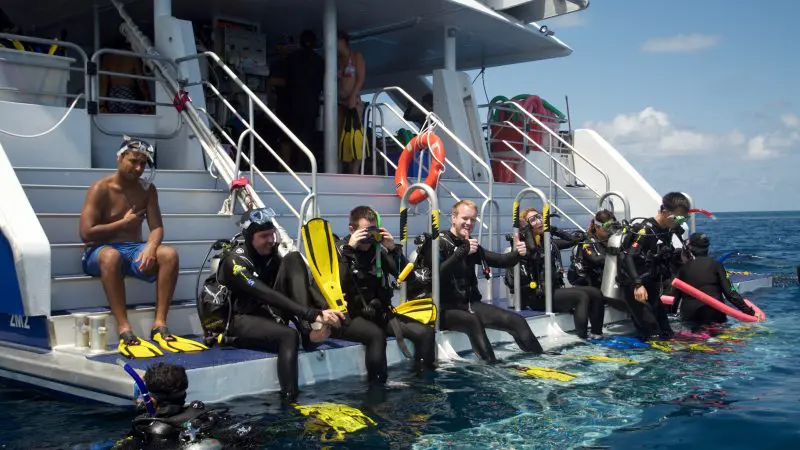Scuba divers equipped with full kit and fins get ready to dive into the sea during a 4 Day 1 Night Rescue Course (Res1N).