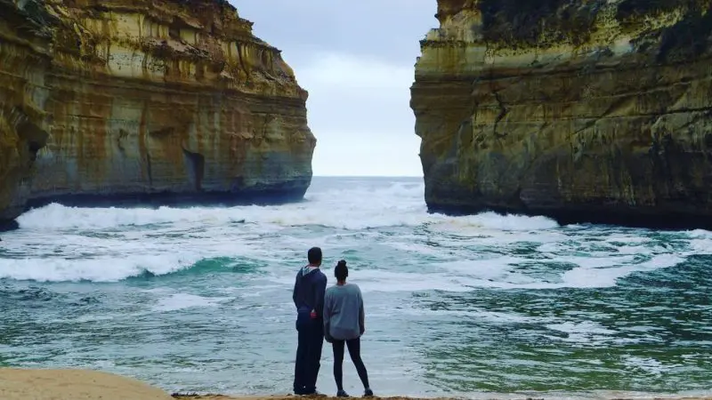 Two travellers discover scenic rocky cliffs and golden sands on the 1 Day Great Ocean Road Tour with Go West, Australia’s coastal wonder.