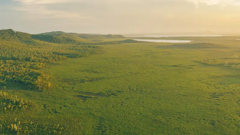Stunning aerial shot of Noosa Everglades with rolling hills, lush greenery, serene lake—ideal for top-rated Everglades Eco Safaris tours.