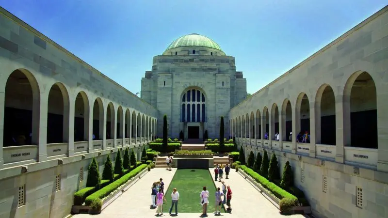 Visitors explore the Australian War Memorial courtyard in Canberra on a Sydney day trip, enjoying sunny skies and iconic scenery.