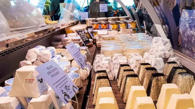 Assorted artisanal cheeses in diverse shapes arranged in a glass deli display case on a relaxed Yarra Valley Winery Tour experience.