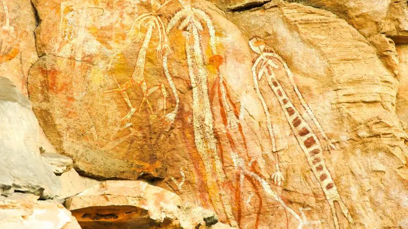 Explore authentic Ancient Aboriginal rock art on a Kakadu Arnhem Land Tour, showcasing detailed human figures on ochre-hued stone.