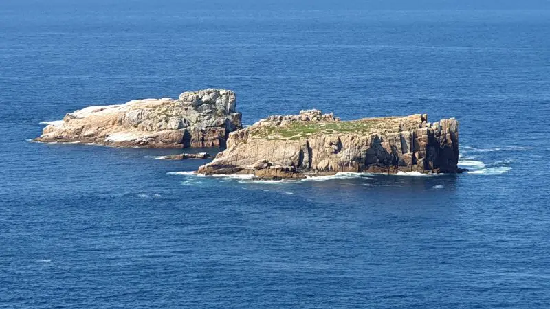 Stunning view of two rocky islands in crystal clear blue sea on Wineglass Bay Full Day Tour near Richmond under a bright sunny sky.