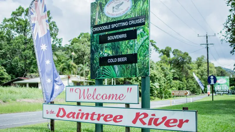 Eye-catching roadside signs greet Daintree River visitors, highlighting 1-Hour River Cruises, local souvenirs, and refreshing cold beer.