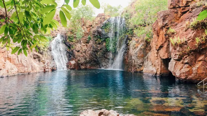 Experience the beauty of Litchfield National Park: twin waterfalls flowing into a crystal-clear rocky pool on a 1-day adventure tour.