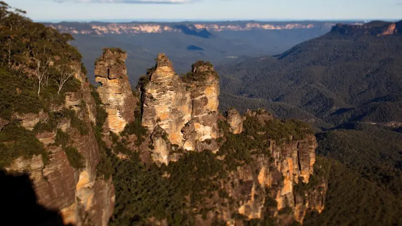 Discover breathtaking views of towering sandstone rock formations above lush forests during a Blue Mountains Sunset Wilderness Tour.