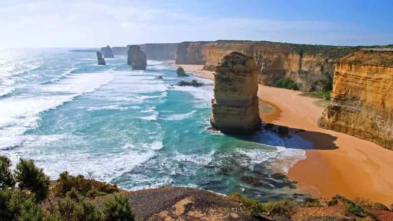 Majestic limestone stacks tower above vibrant turquoise waves on the Great Ocean Road Day Tour with Go West, a top-rated adventure.
