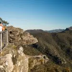 Woman enjoys breathtaking views of Grampians peaks from scenic lookout during a 1 Day Grampians Eco Wilderness Escape tour.