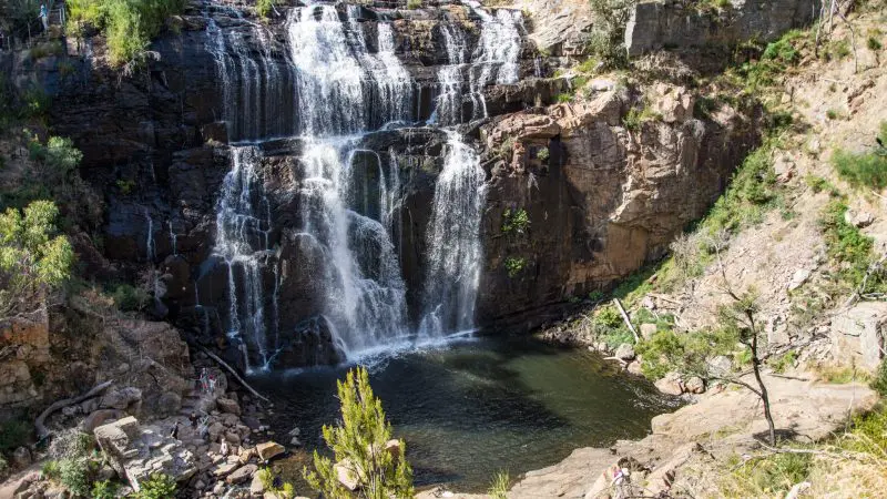 Experience the breathtaking sight of a tall waterfall flowing over rugged cliffs on the 3 Day Great Ocean Road Grampians Explorer tour.