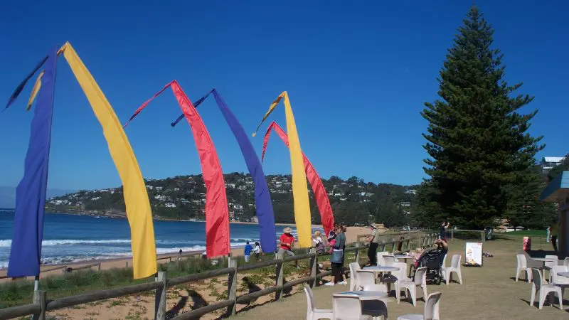 Vibrant flags flutter near a picturesque beachside lounge, ideal for Celebtime Tours' top-rated 1 Day Home Away getaway experience.