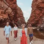 Four adventurers marvel at dramatic red cliffs and a crystal-clear pool on a 1 Day West MacDonnell Ranges tour with Standley Chasm.