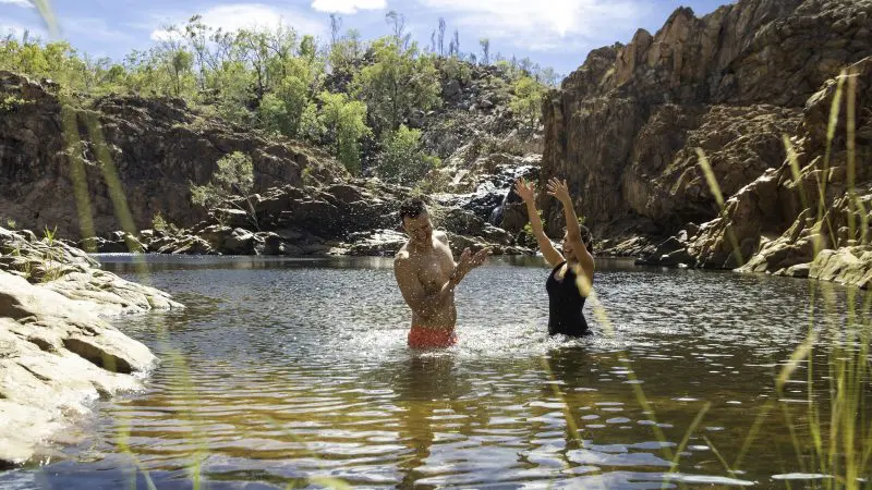 Two travellers enjoying a refreshing swim in a rocky pool at Kakadu during the 4-Day Kakadu Katherine Gorge Experience from Darwin.