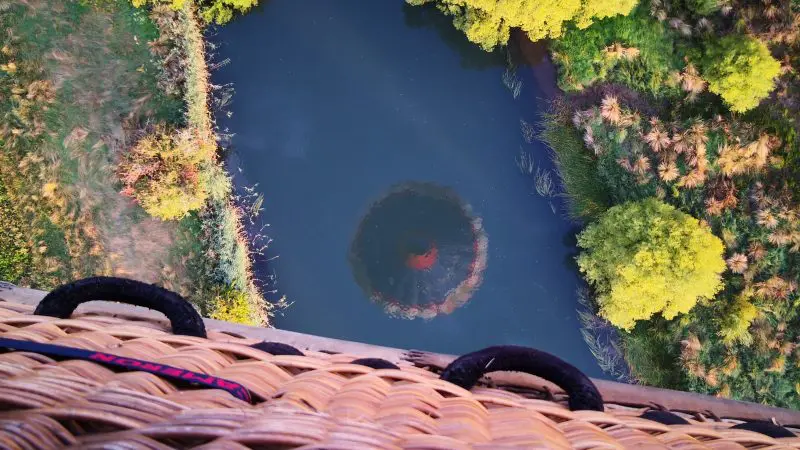 Breathtaking aerial view from a Perth Avon Valley hot air balloon over winding river, lush trees, and scenic reflections at sunrise.