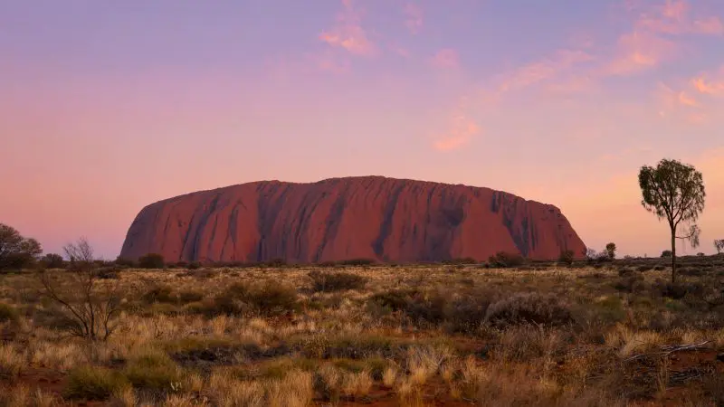 Uluru glowing at sunset on a 3 Day Red Centre Kings Canyon Safari tour from Alice Springs, Australia—iconic Outback adventure.