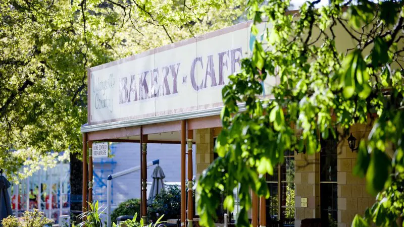 Inviting bakery café sign on a sunny patio, ideal for a delicious pre-tour stop before your Lake Mountain Snow Waterfalls adventure.