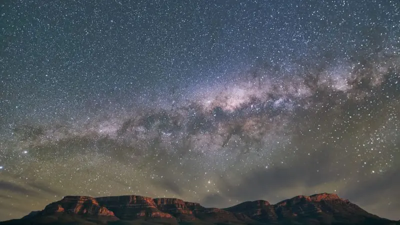 Breathtaking Milky Way over mountain peaks on a 7 Day Uluru to Adelaide Untamed Escapes tour, perfect for stargazing adventures.
