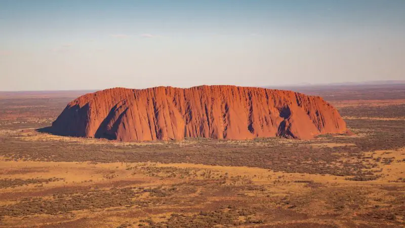 Stunning aerial view of Uluru in Australia’s Red Centre, iconic landmark on the 7 Day Adelaide to Uluru Untamed Escapes adventure tour.