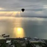 Hot air balloon at sunrise over The Great Ocean Flight Geelong and Bellarine, calm waters, ships below, breakfast included.