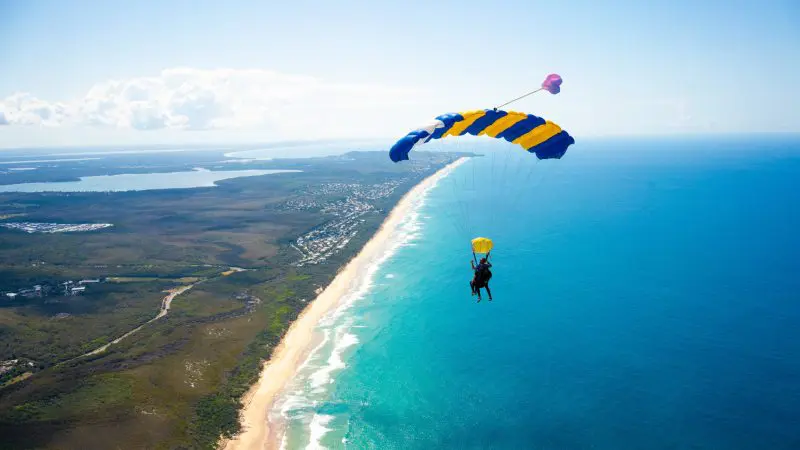Tandem skydivers with Skydive Noosa freefalling at 15,000ft over Australia’s breathtaking coastline and vibrant blue ocean views.