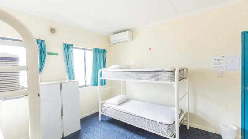Spacious, sunlit dormitory room featuring sturdy metal bunk beds—perfect stay for your Perth to Broome West Coast Adventure trip.