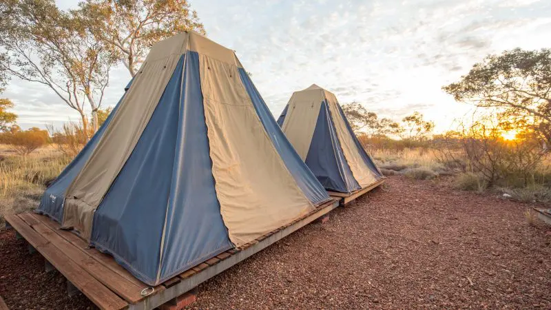 Experience sunrise in the outback with two canvas tents on wooden decks—ideal Perth to Darwin glamping for adventure travellers.