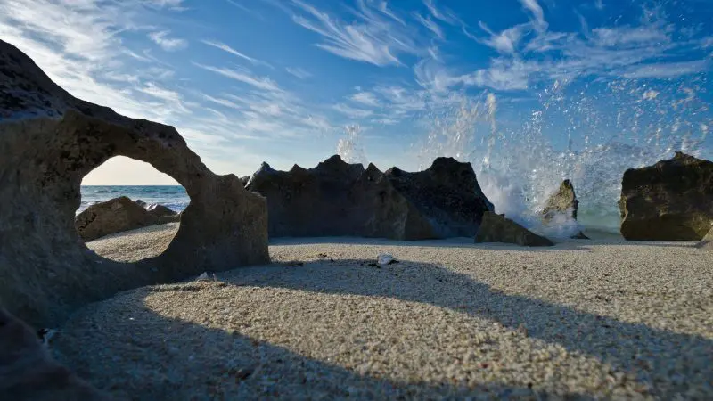 Dramatic rocky beach with unique rock hole foreground on the Broome to Perth West Coast Adventure, iconic Australia travel highlight.