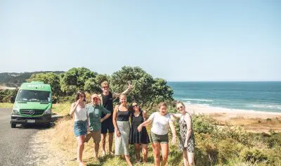 Energetic group of friends posing for a photo, enthusiastically performing the Funky Chicken dance with big smiles and playful gestures.