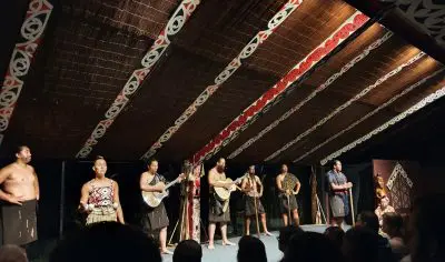 Energetic performers on stage light up a sold-out Kiwi tour in New Zealand, captivating audiences with dynamic live entertainment.