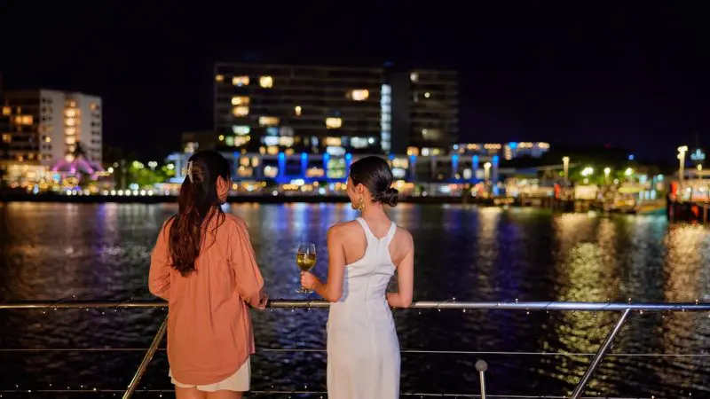 Ladies having a drink on the deck of spirit of cairns at nighttime