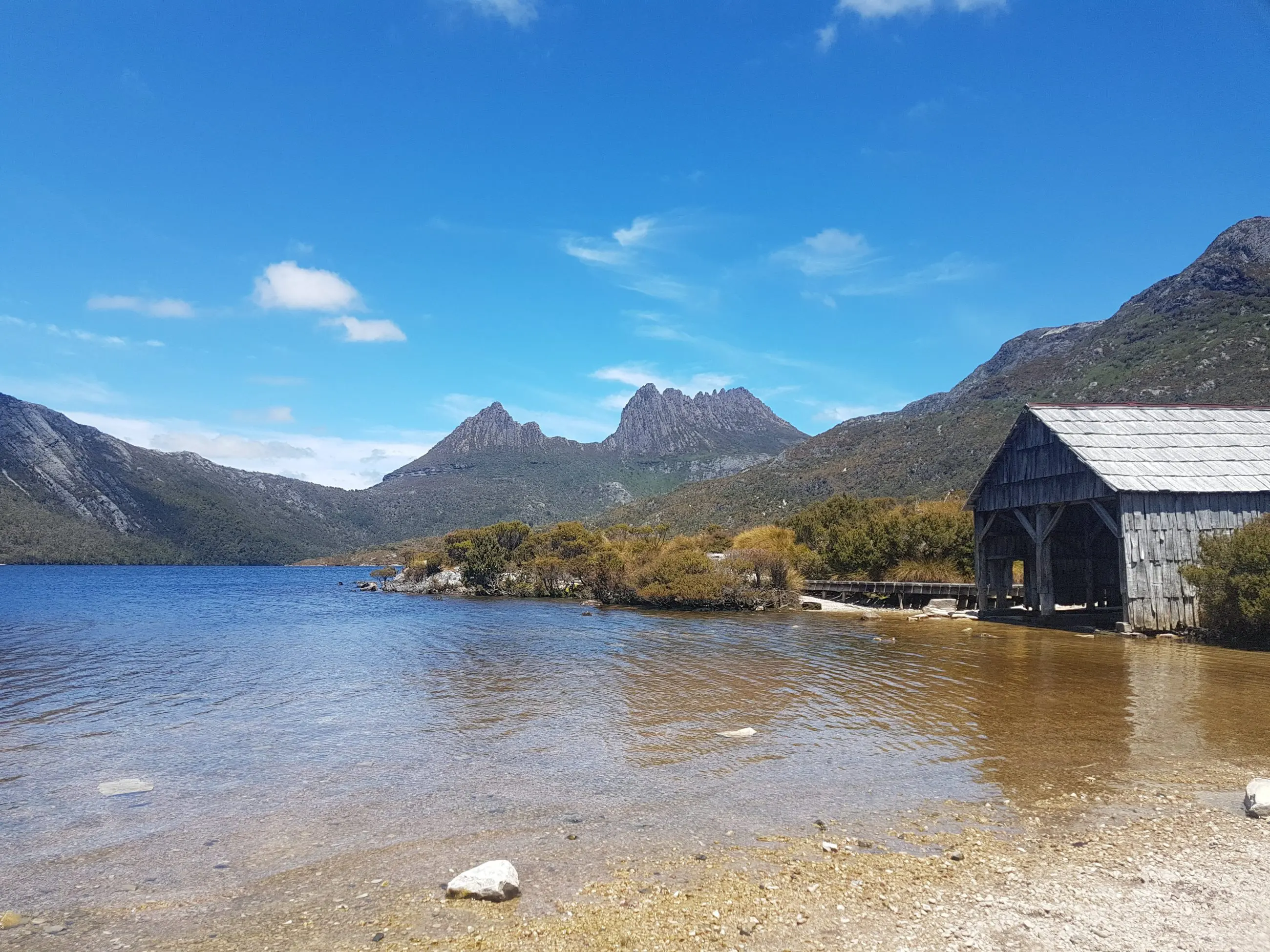 Scenic rustic boathouse on crystal-clear lake at Cradle Mountain, featured on a top-rated 2-Day Hobart tour with Wild Tasmania Tours.