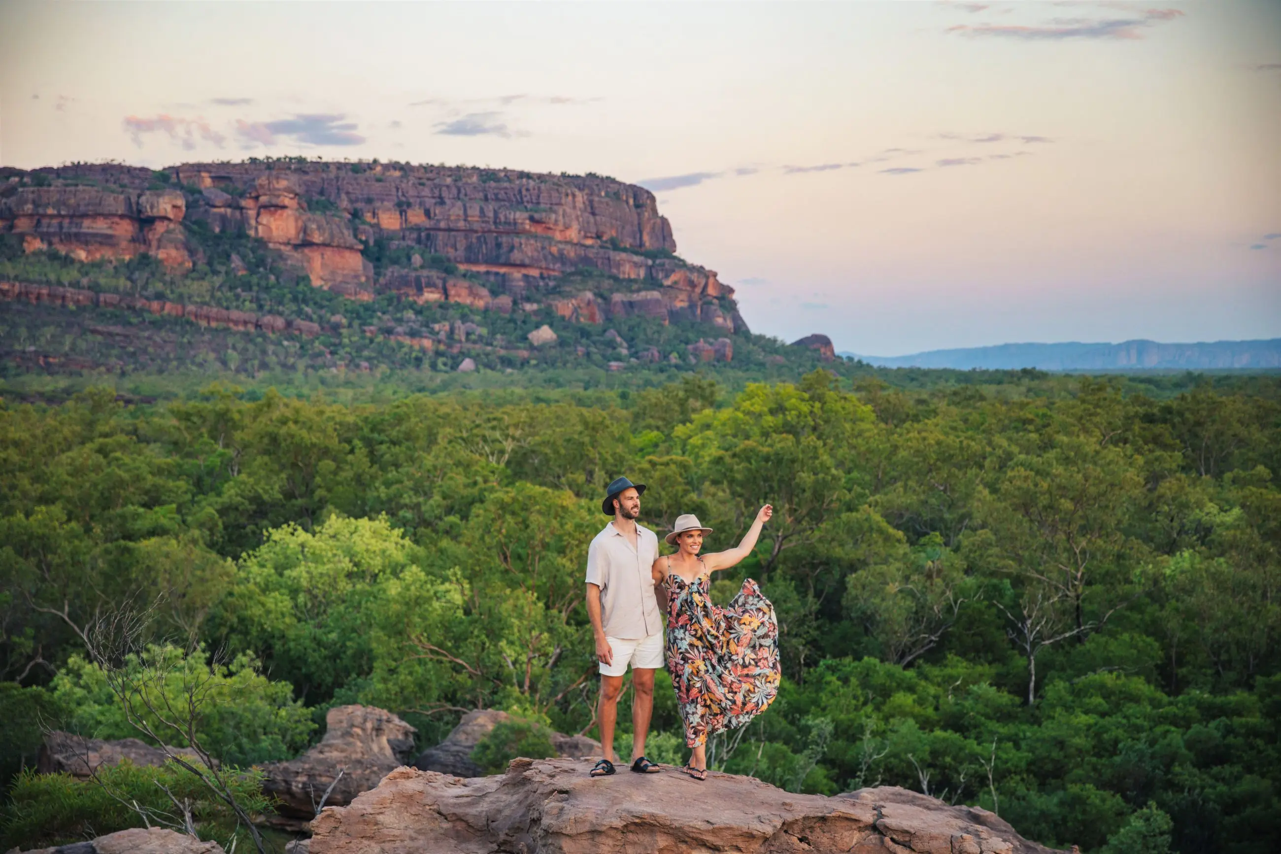 A couple explores rocky terrain at sunset on a 5 Day Kakadu, Katherine Gorge & Litchfield 4WD Adventure departing from Darwin.